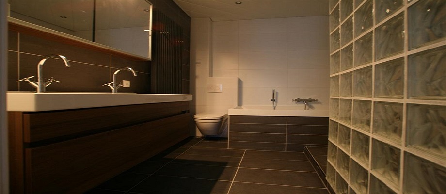Badkamer met glazen bouwstenen, dubbel badmeubel en ligbad