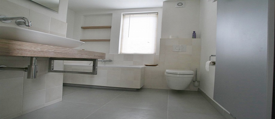 Lichte badkamer met hangtoilet, ligbad en zwevende wastafel