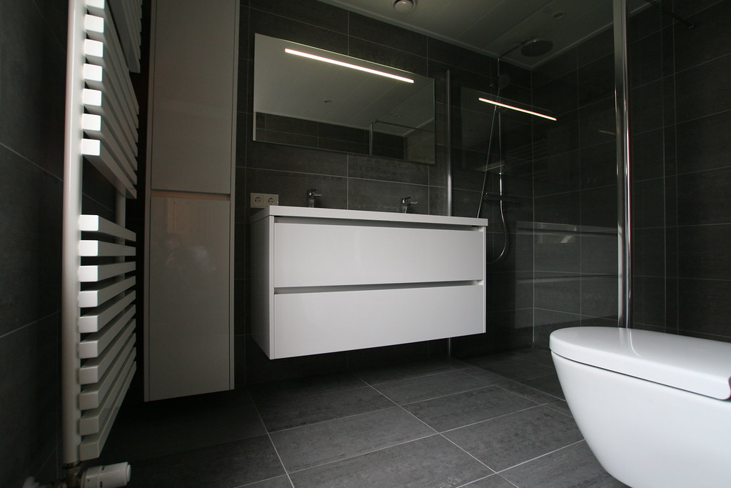 Moderne grijze badkamer met wit meubel en designradiator